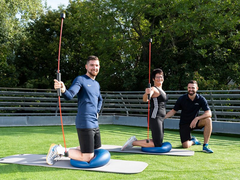 Therapeut mit zwei Patienten beim Training auf der Dachterrasse vom Rehazentrum Wöhrderwiese in Nürnberg.